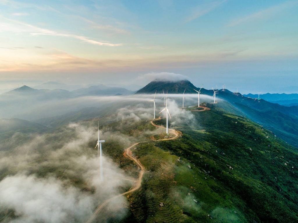 aerial photograph of wind farm with mountain in background