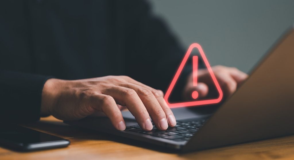 Investment manager at a workstation examining a fund factsheet on his laptop returning an error
